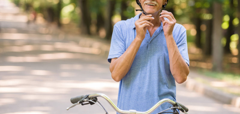 smiling-man-is-wearing-helmet-while-sitting-on-bicycle